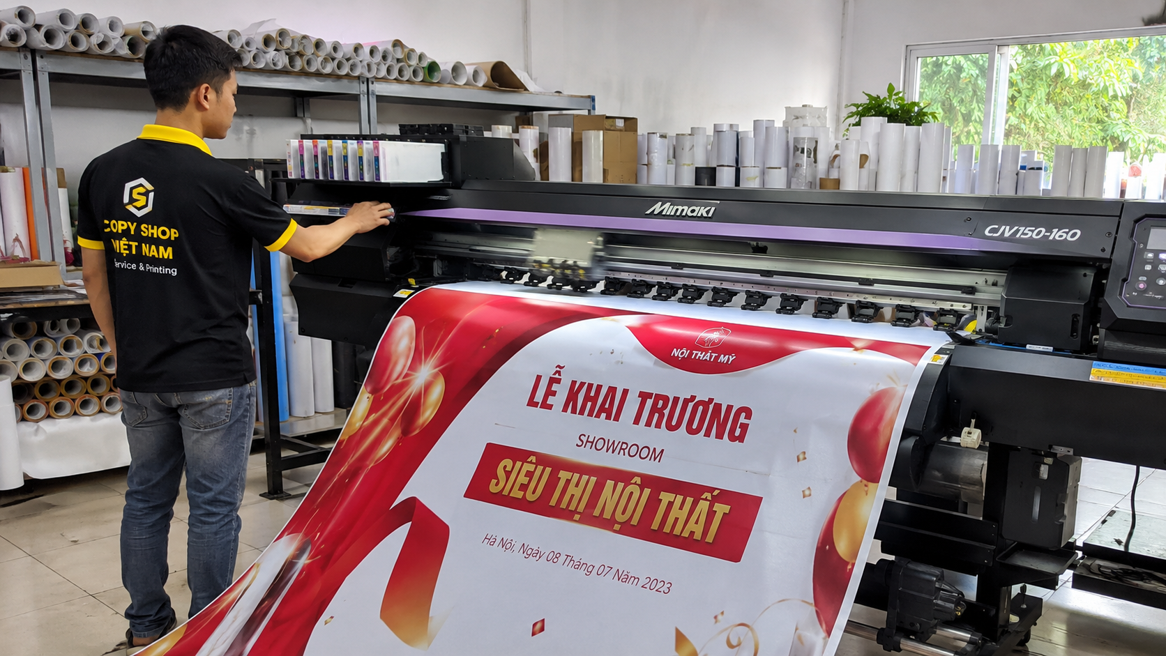 Mẫu Backdrop Khai Trương 1 Công nhân vận hành máy in khổ lớn sản xuất mẫu backdrop khai trương