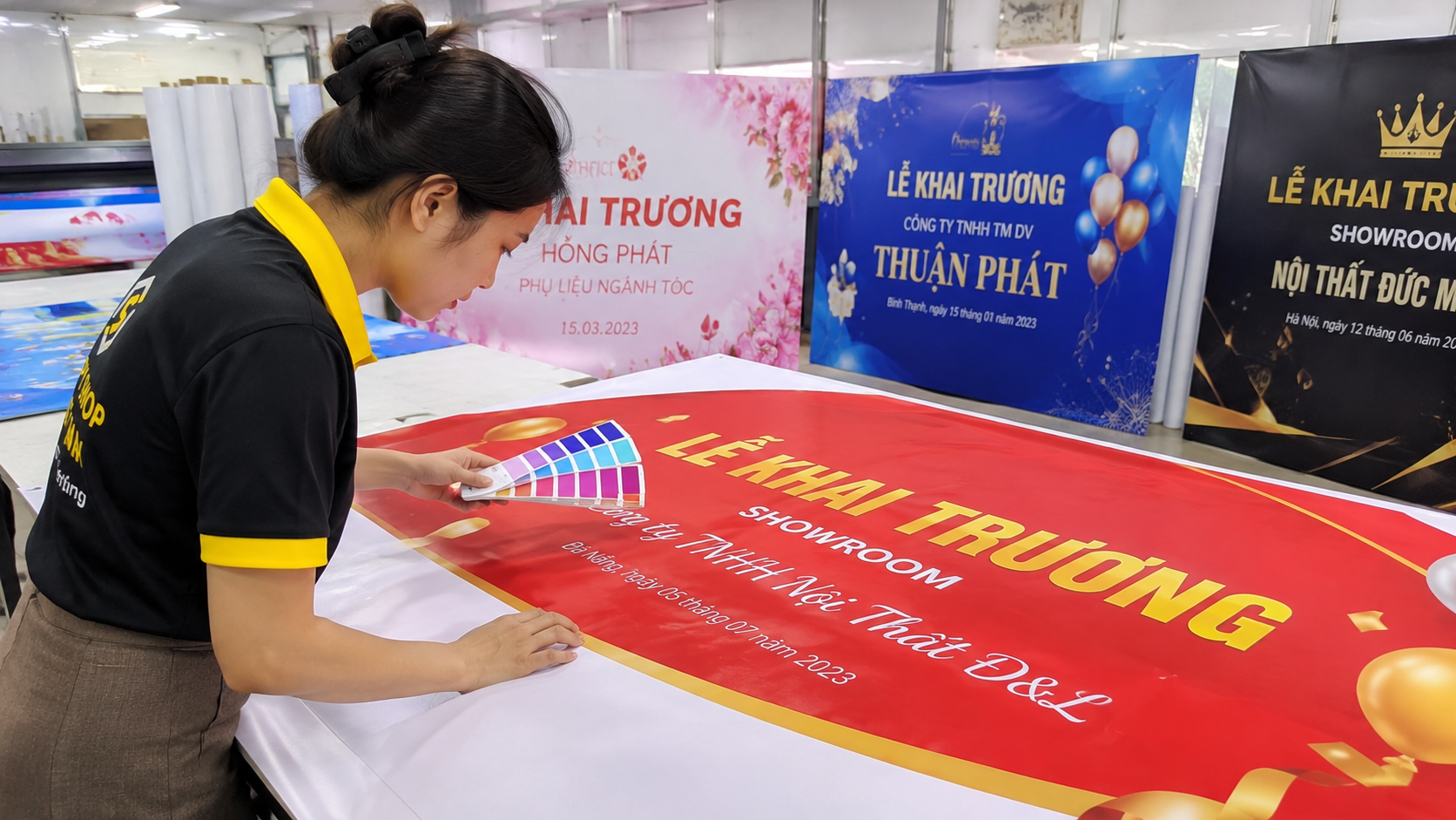 Mẫu Backdrop Khai Trương 2 Nhân viên kiểm tra màu sắc mẫu backdrop khai trương sau in